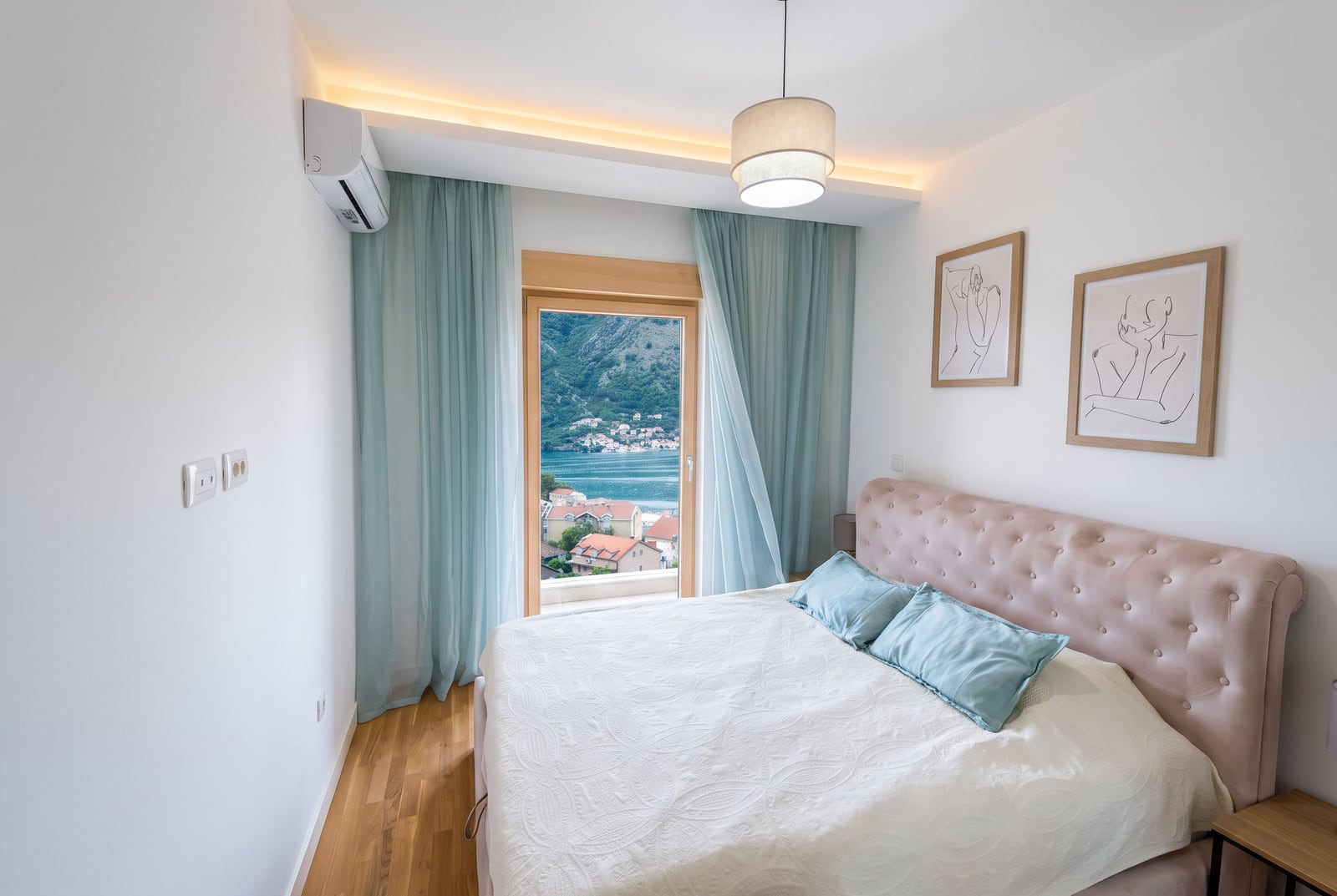 Bedroom with a double bed and a view of the Bay of Kotor in an apartment, Dobrota, Montenegro.