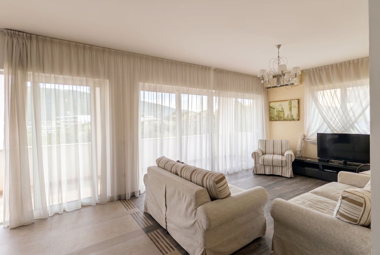 Bright living room with upholstered furniture and panoramic windows in an apartment in Kumbor, Montenegro.