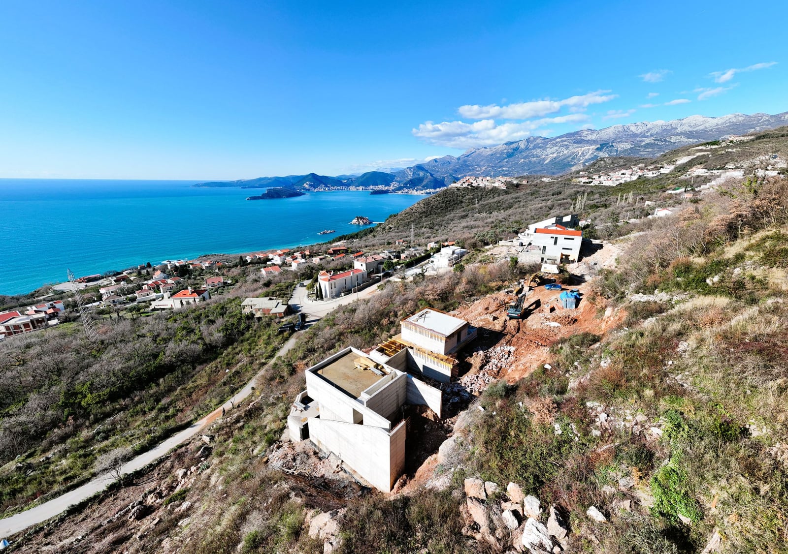Villas under construction on a plot in Blizikuće, Montenegro, with panoramic views of the Adriatic Sea and the mountains.