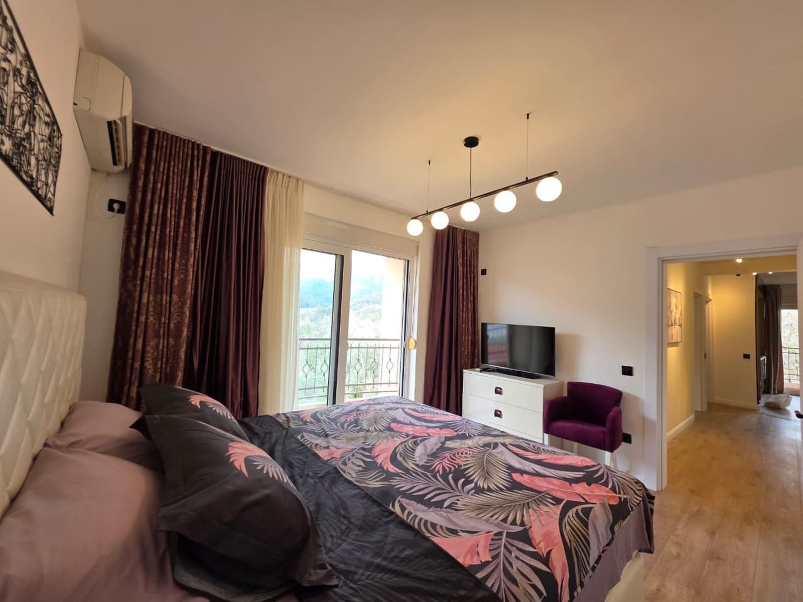 Cozy bedroom with a double bed and access to the balcony in an apartment in Bečići, Montenegro. Modern interior.