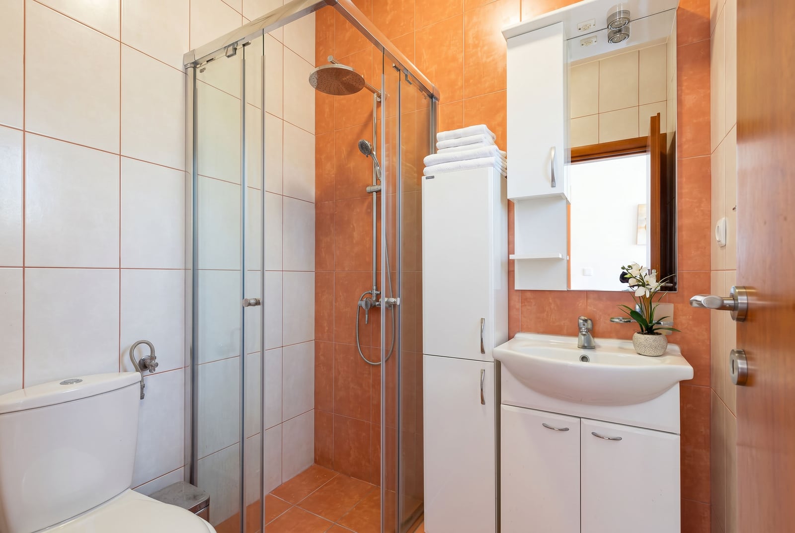Bathroom with a walk-in shower and white furniture in a villa in Becici, Montenegro. Modern tile finishes.