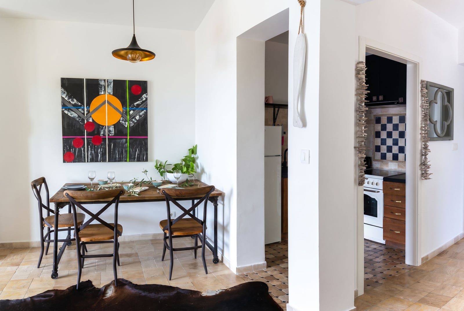 Interior of a living room with a dining area in an apartment, Risan, Montenegro: wooden table, vintage chairs, and kitchen.