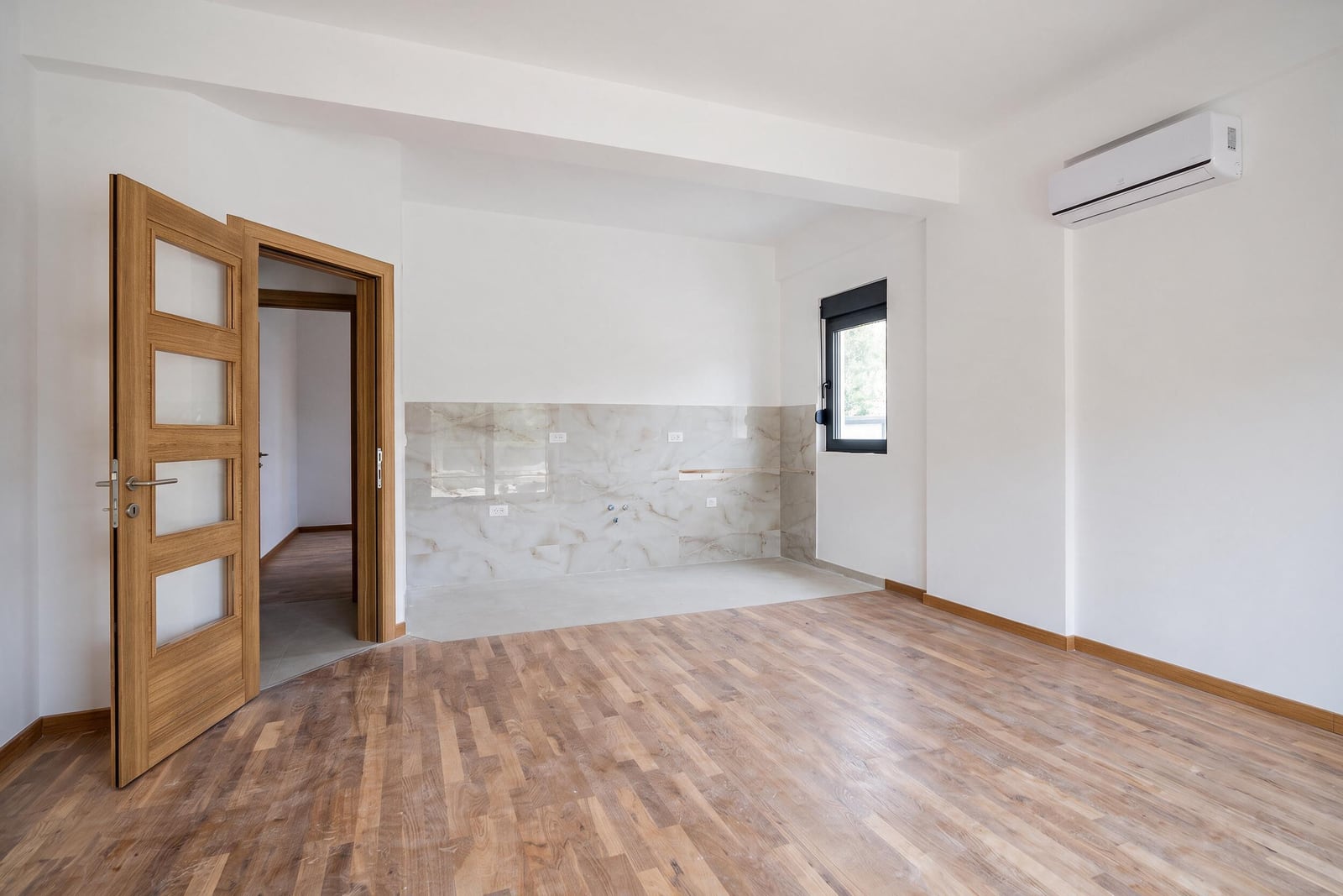 Bright living room with parquet flooring, kitchen area, and air conditioning in an apartment in Bar, Montenegro