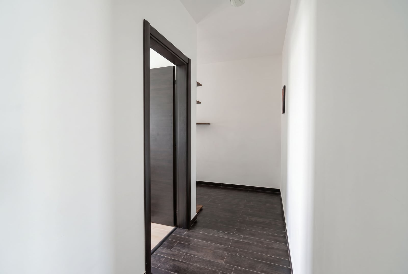 Bright hallway with dark flooring and an interior door in an apartment, Kumbor, Montenegro.