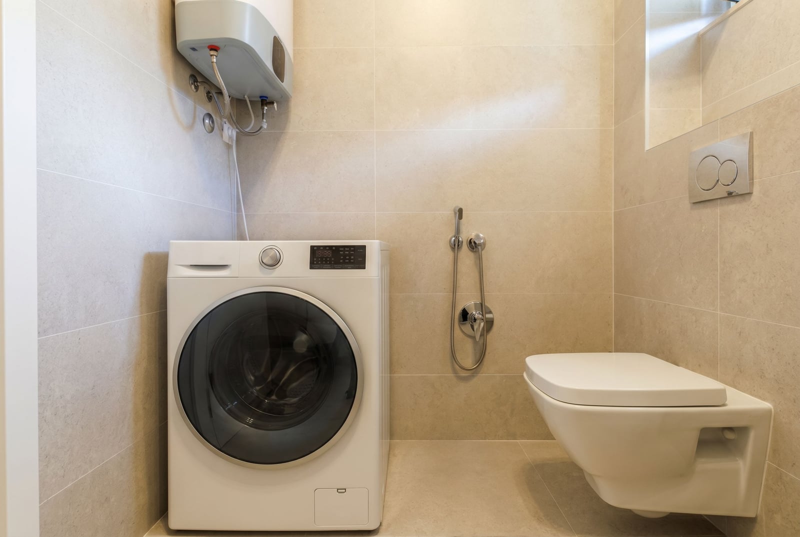 Modern bathroom in a penthouse in Bečići, Montenegro: washing machine, wall-hung toilet, and water heater.