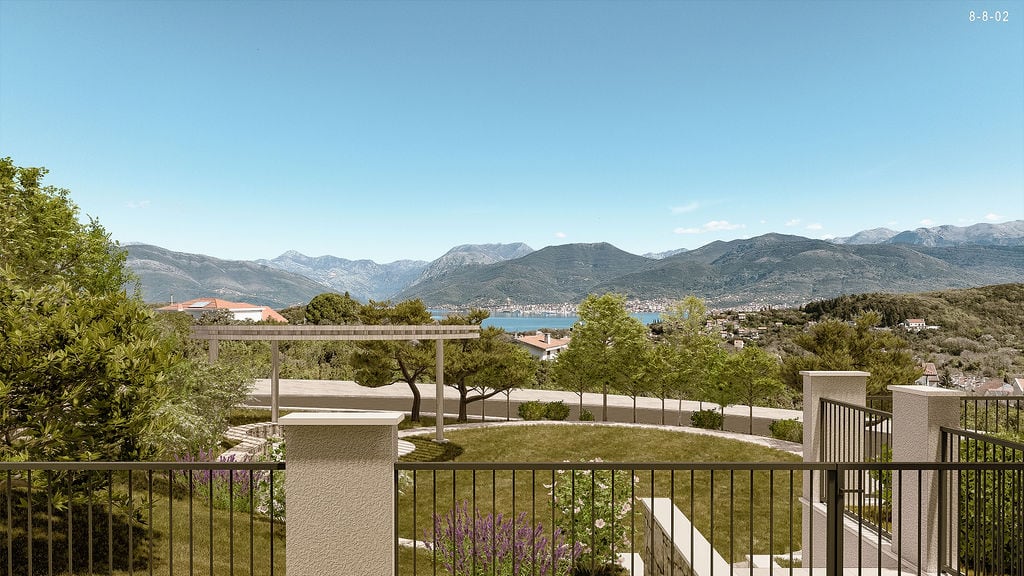 Panoramic view of the mountains and sea from a residential complex in Luštica, Montenegro, with a landscaped terrace and garden.