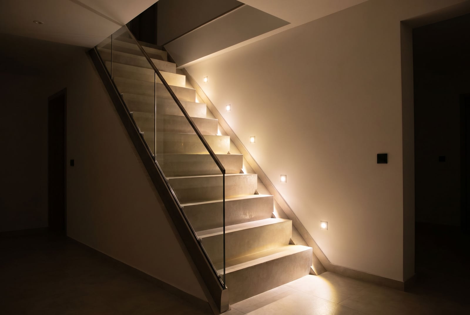 Modern staircase with step lighting and glass railing in an office space, Budva, Montenegro.