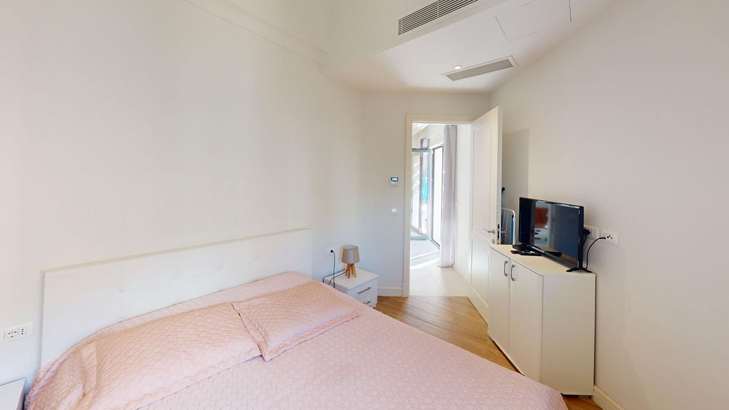 Bright bedroom with a double bed and TV in a modern apartment, Luštica, Montenegro.