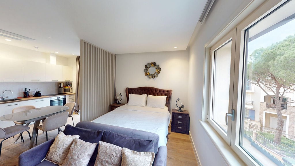 Modern studio with kitchen and sleeping area in Luštica, Montenegro: stylish interior, view of the pines from the window.