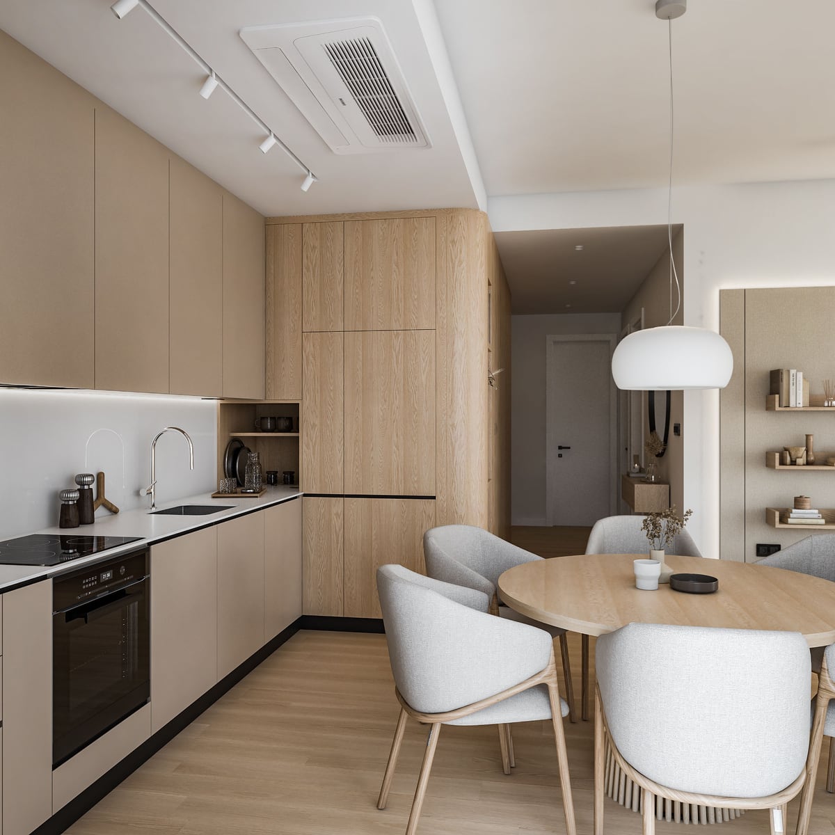 Modern kitchen with beige cabinets, wood accents, built-in oven and stove, sink, and a dining area with light grey chairs around a round table.