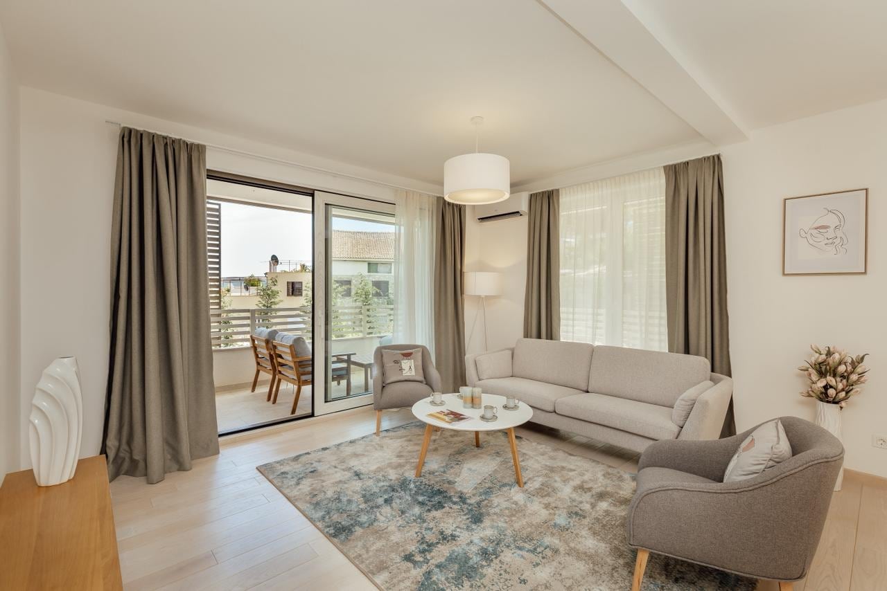 Bright living room with furniture and terrace access in an apartment in Igalo, Herceg Novi, Montenegro.