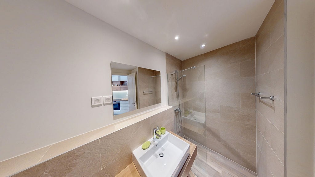 Modern bathroom with a shower cabin in an apartment, Luštica, Montenegro: beige tiles and stylish sanitary ware.
