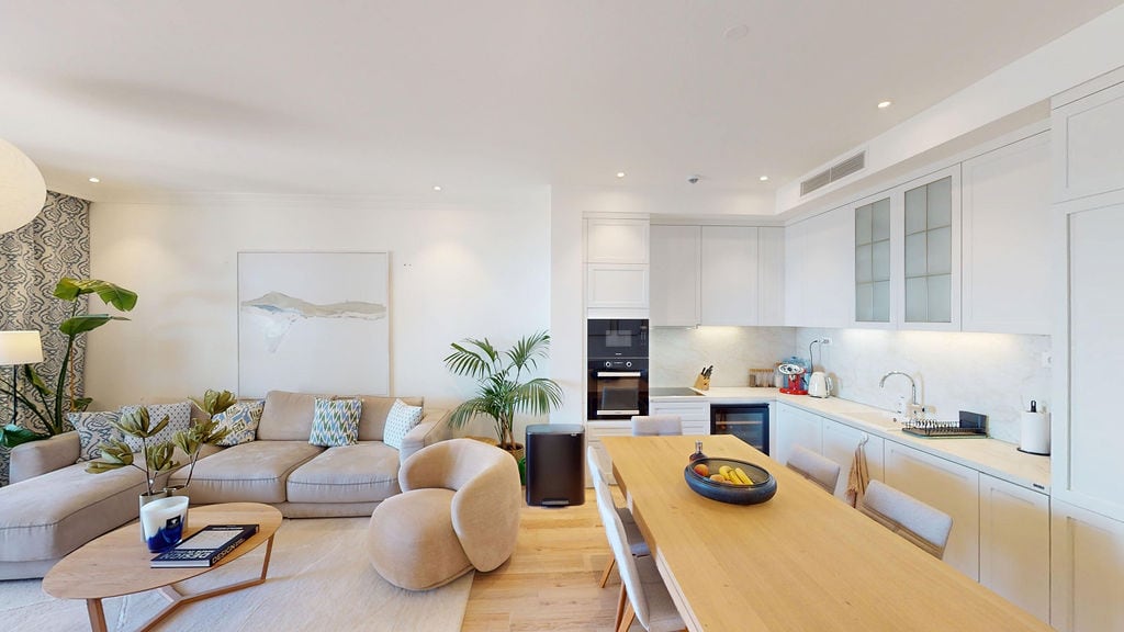 Modern living room with kitchen in an apartment, Luštica, Montenegro: bright interior, upholstered furniture, and dining area.