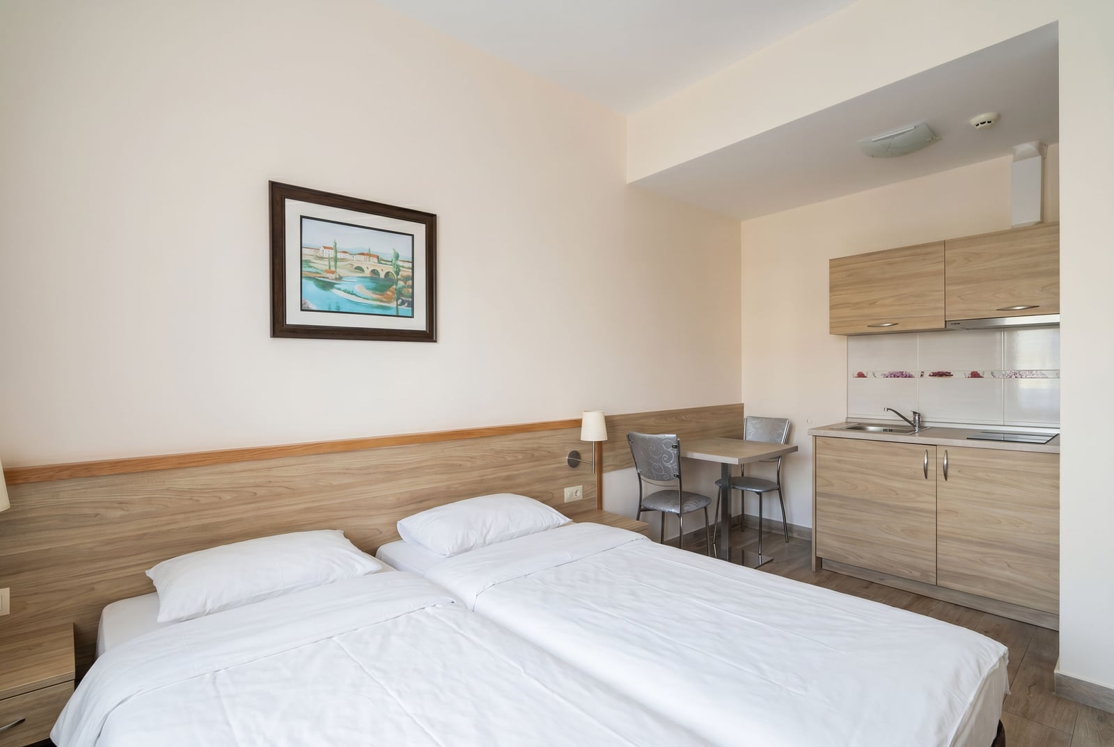 Bedroom with a double bed and kitchenette in an apartment, Becici, Montenegro: modern interior and furniture.