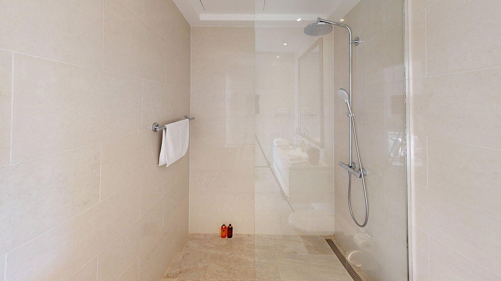 Modern shower cabin with beige tiles in an apartment in Luštica, Montenegro: stylish bathroom interior.