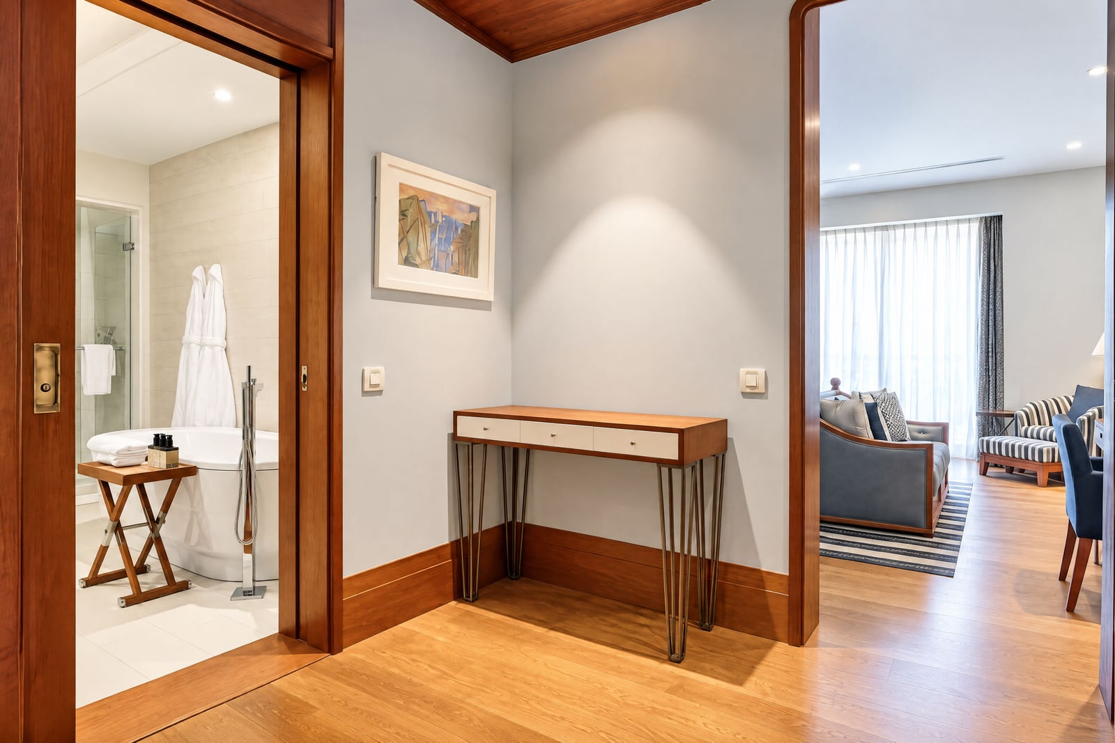 Foyer with a console table, bathroom visible on the left and living room on the right.