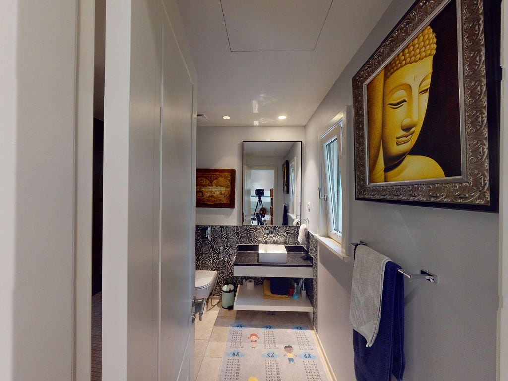 Modern bathroom in a townhouse, Luštica, Montenegro: mosaic tiles, vessel sink, and Buddha decor.
