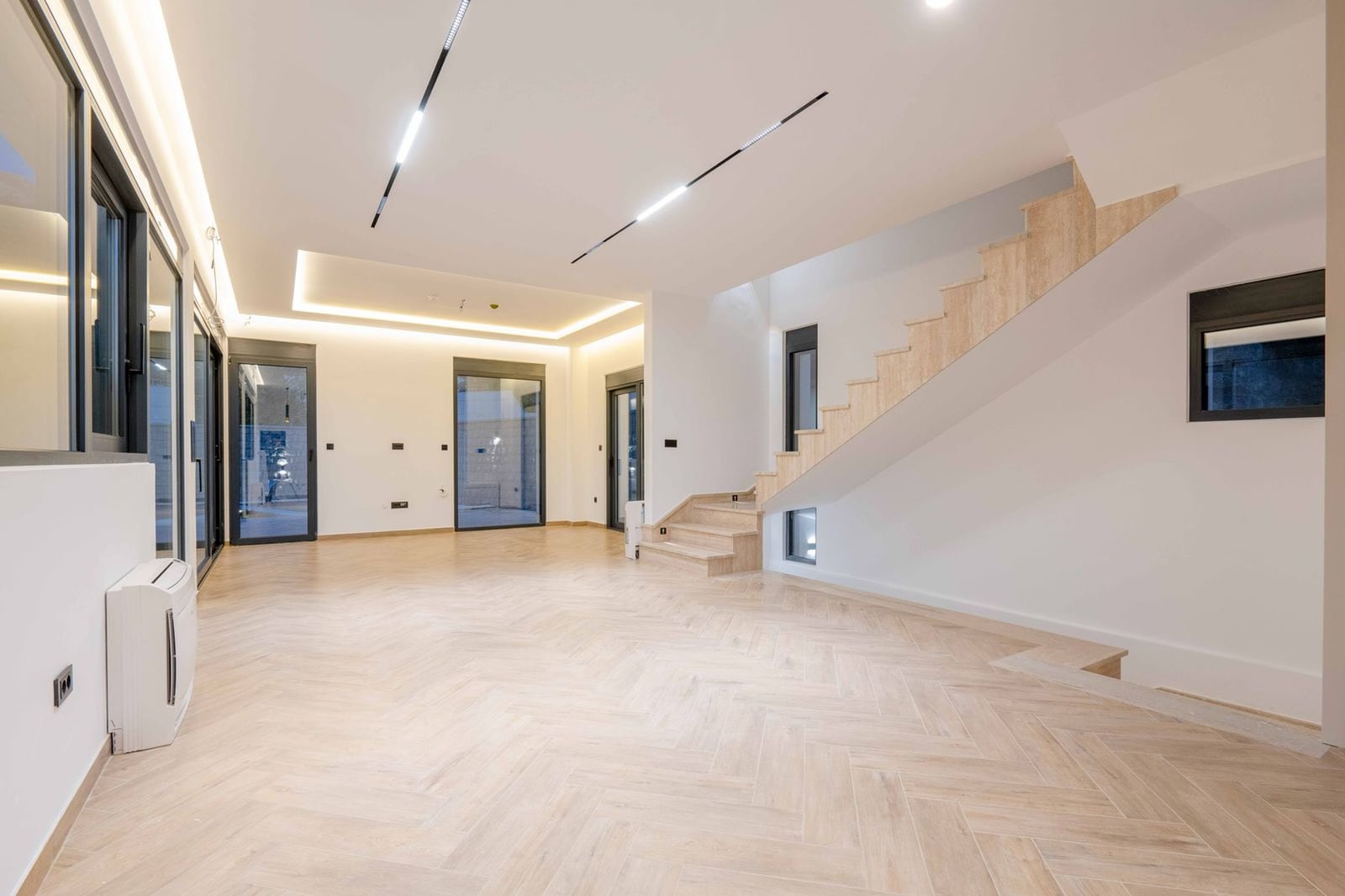 Spacious living room with a staircase and light parquet flooring in a modern villa, Kamenovo, Montenegro.