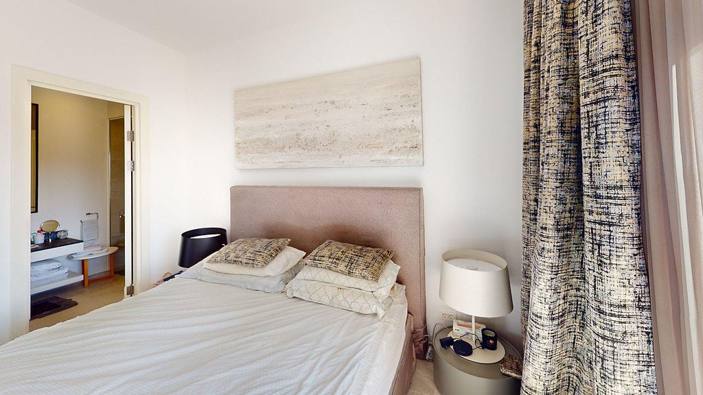 Cozy bedroom with a double bed and bathroom in Luštica apartments, Montenegro. Modern interior.