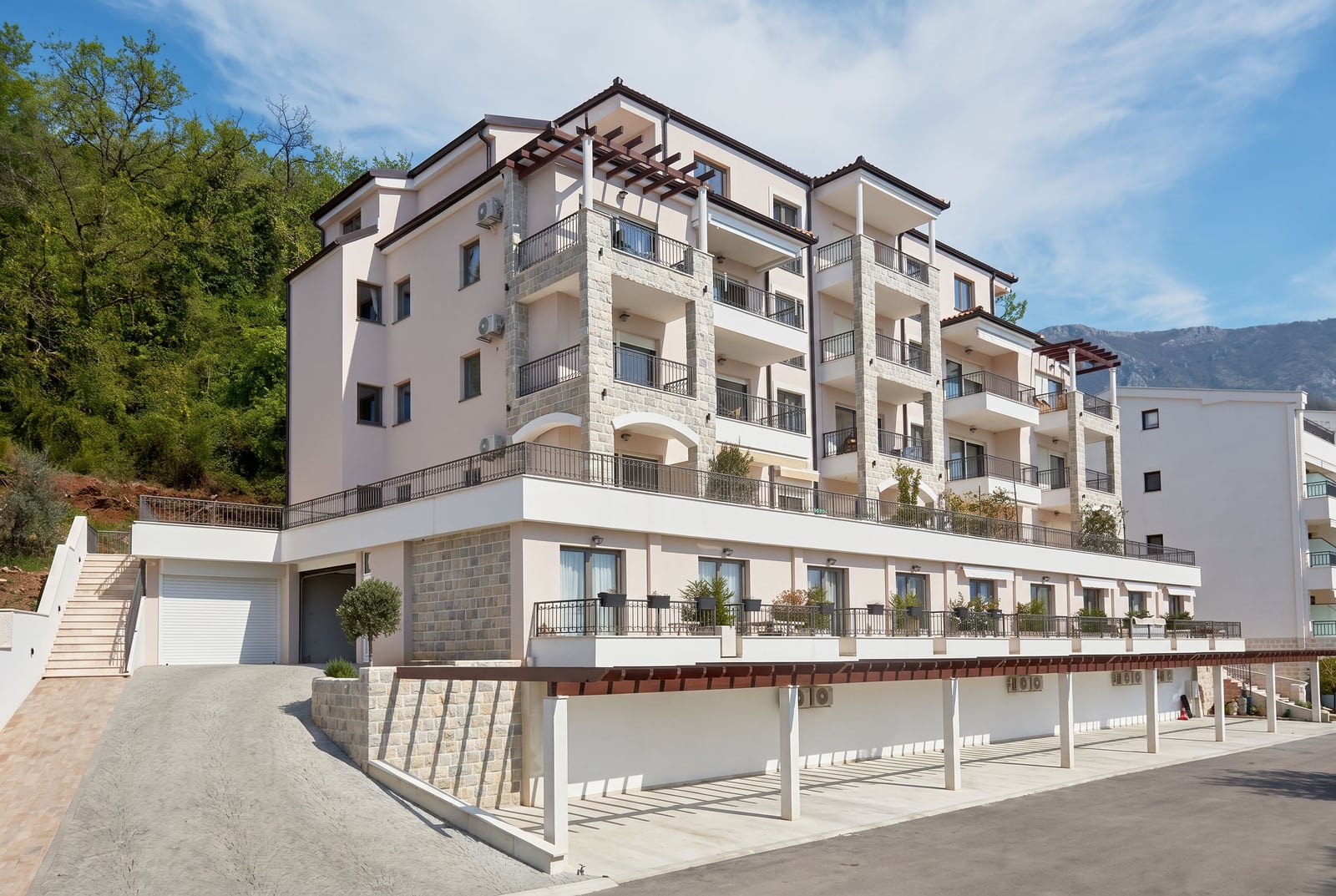 Modern residential complex with terraces and parking in Pržno, Montenegro: view of the building facade with stone cladding.