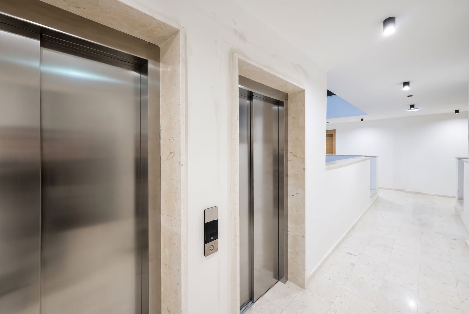 Modern lounge hall with stone finishes and white walls in a residential complex in Budva, Montenegro.