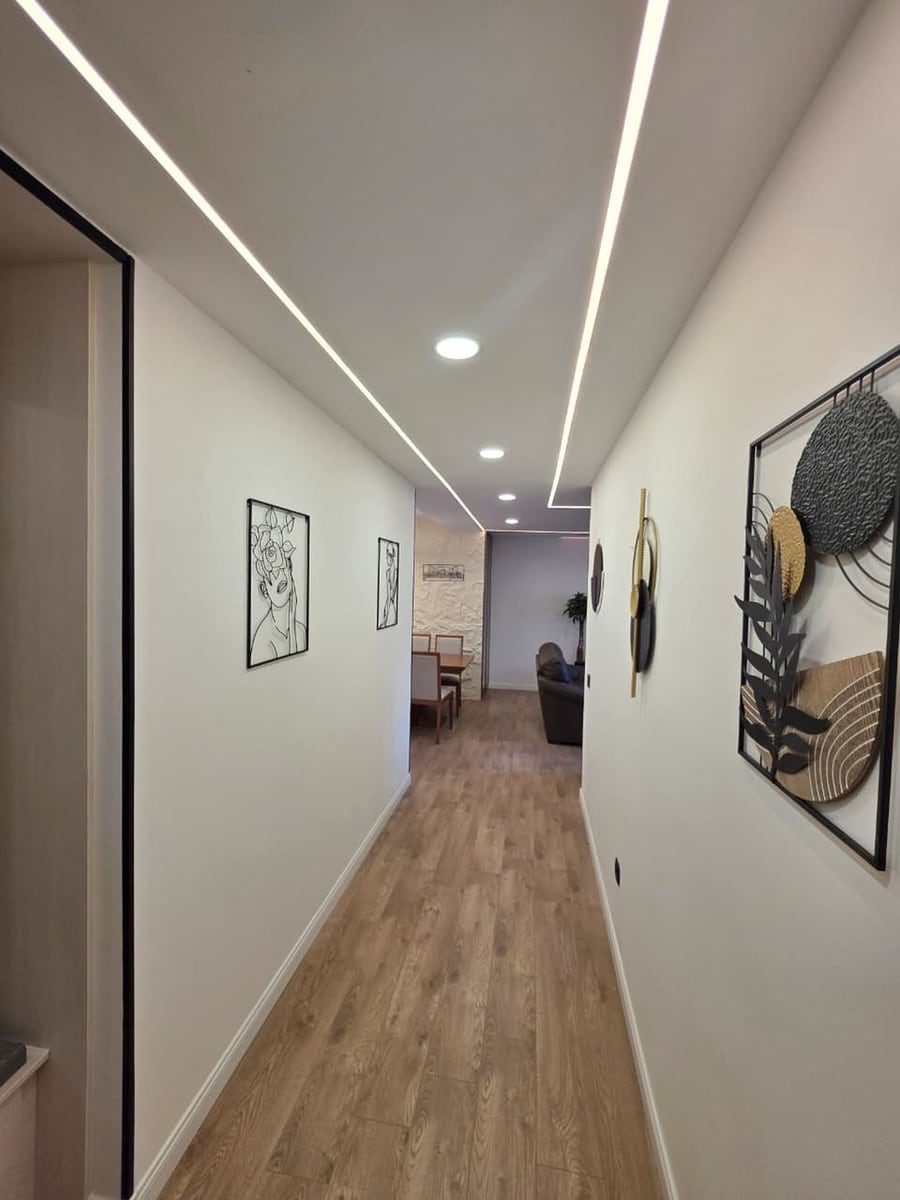 Modern hallway with linear lighting and decor in an apartment, Becici, Montenegro. High-quality interior renovation.