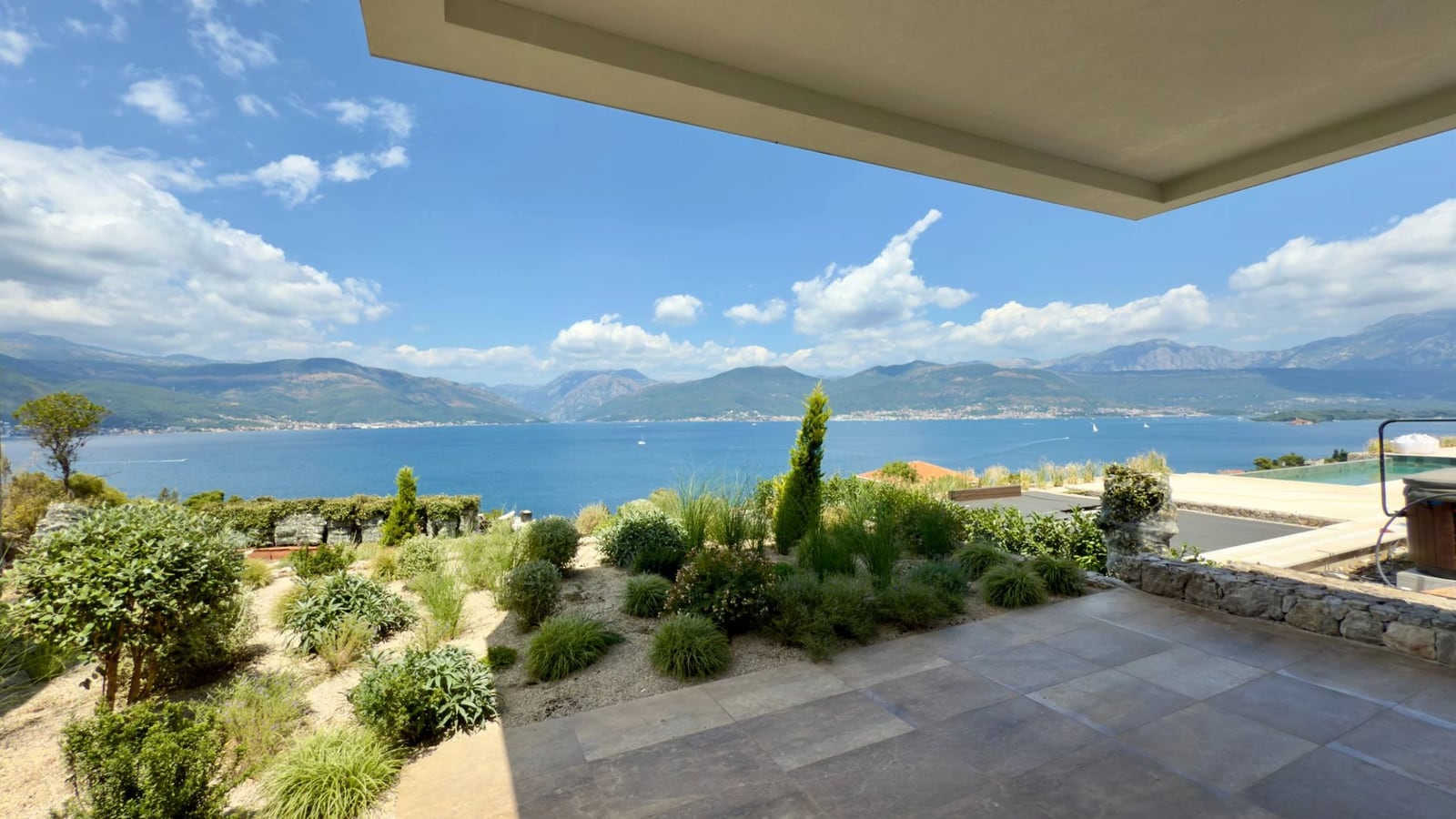 Panoramic sea and mountain view from the villa terrace in Krašići, Montenegro: landscaping and tiled flooring.