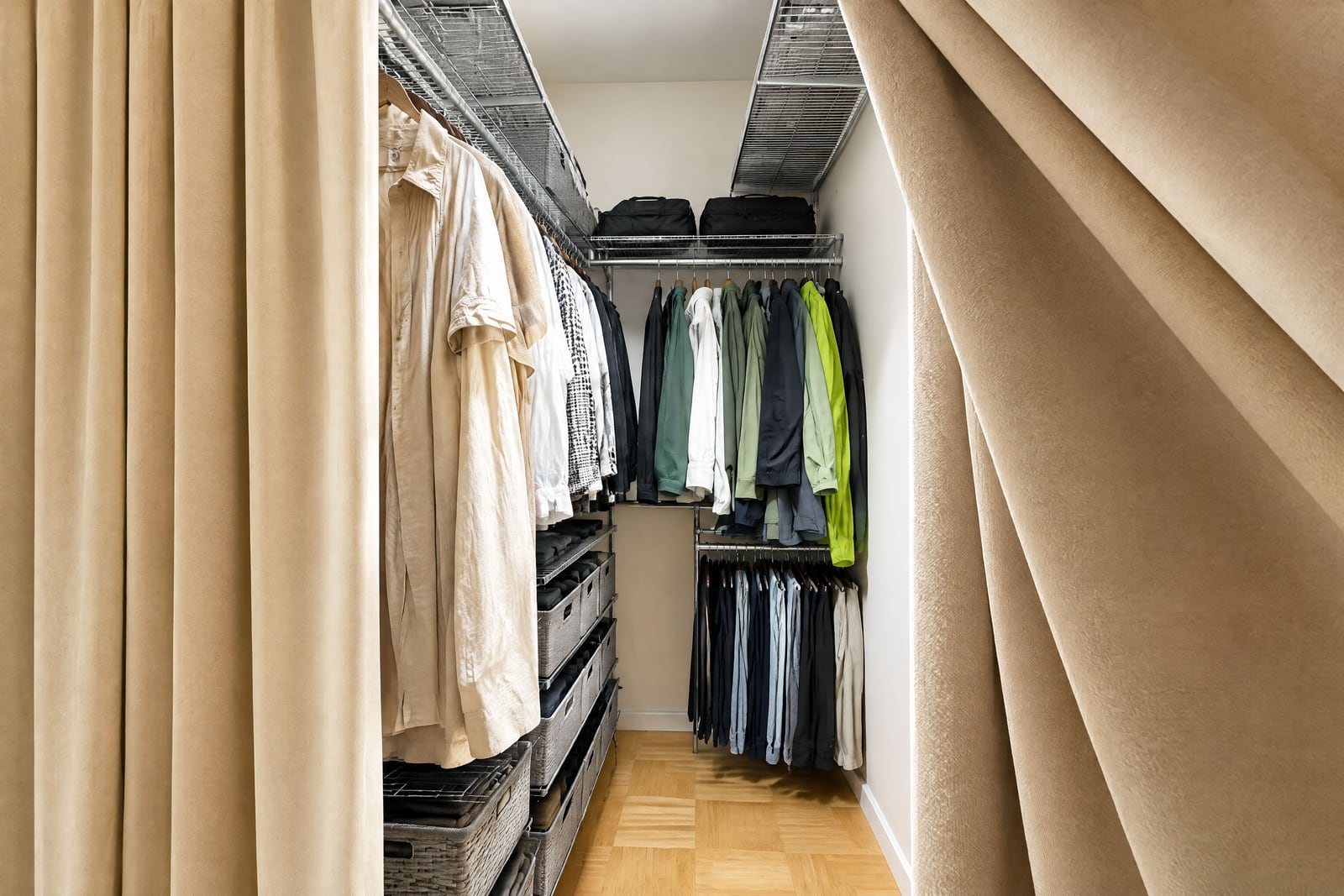 Walk-in closet with metal shelving, hanging clothes, and beige fabric curtains on the sides.