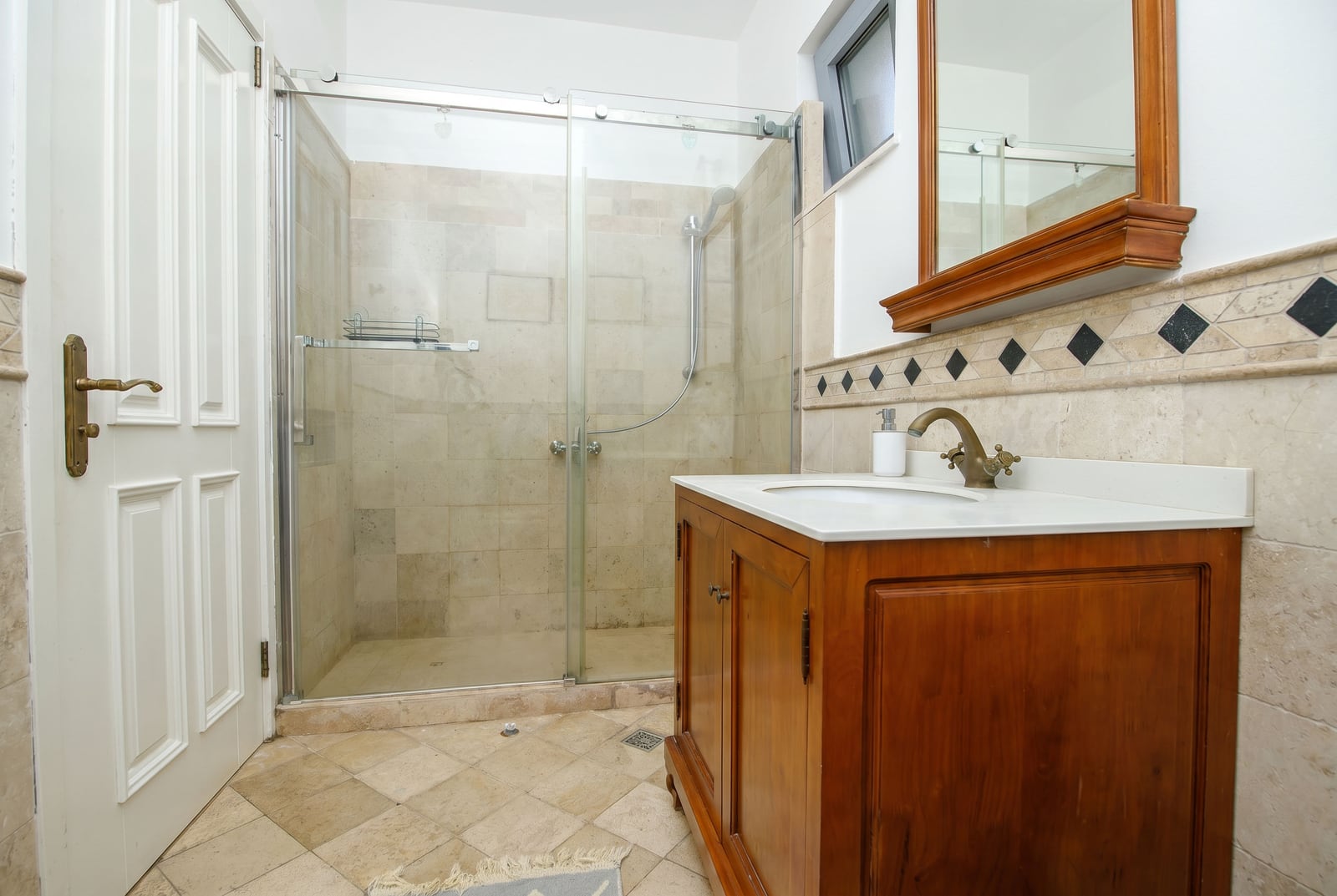 Bathroom in an apartment in Risan, Montenegro: shower cabin, wooden vanity unit under the sink, and tiled finish.