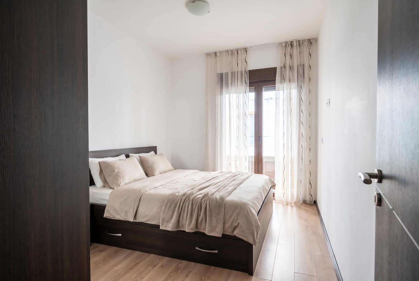 Bright bedroom with a double bed and balcony access in an apartment in Budva, Montenegro