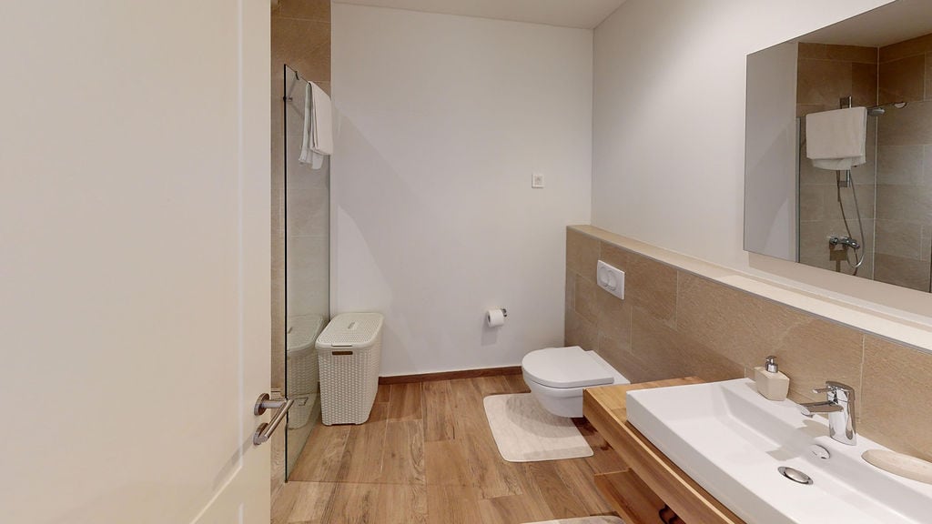 Modern bathroom in an apartment in Luštica, Montenegro: shower cabin, wall-hung toilet, and stylish finishes.
