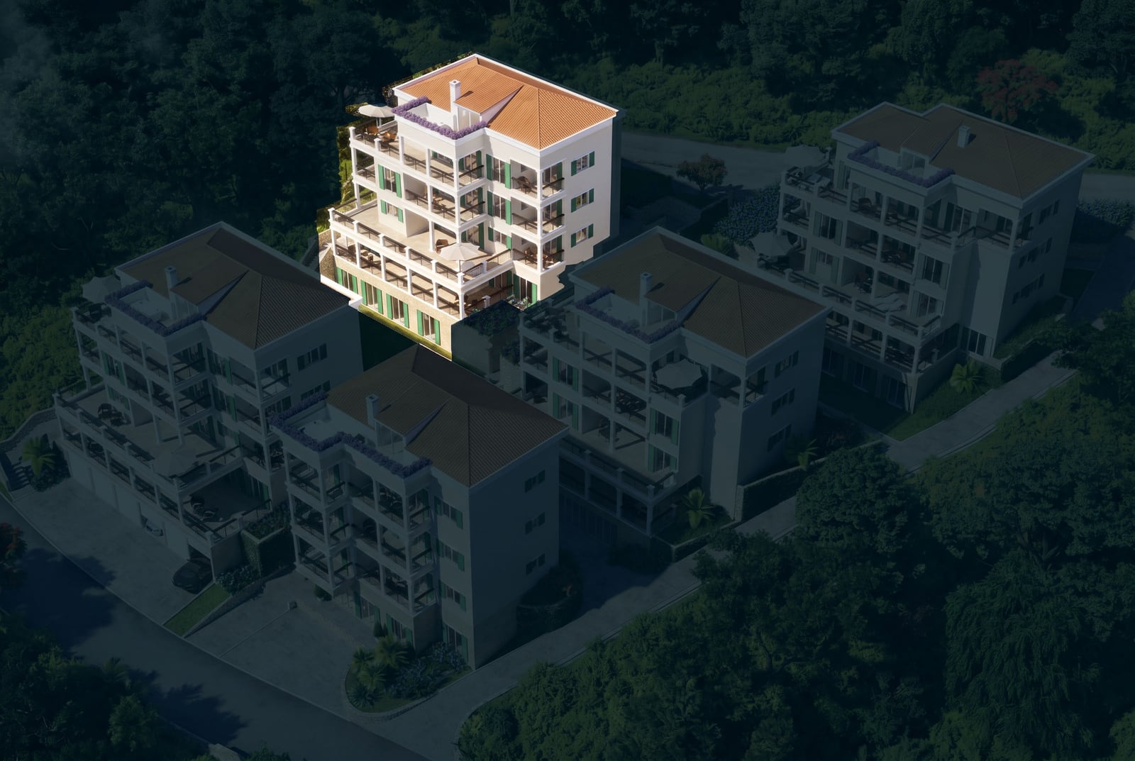 Aerial view of a residential complex in Kumbor, Montenegro: modern houses with terraces and tiled roofs surrounded by forest.