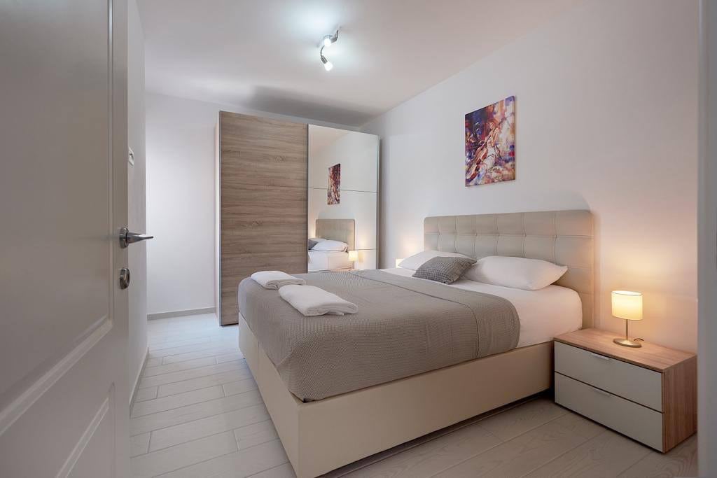 Modern bedroom with a double bed and a mirrored wardrobe in an apartment, Przno, Montenegro