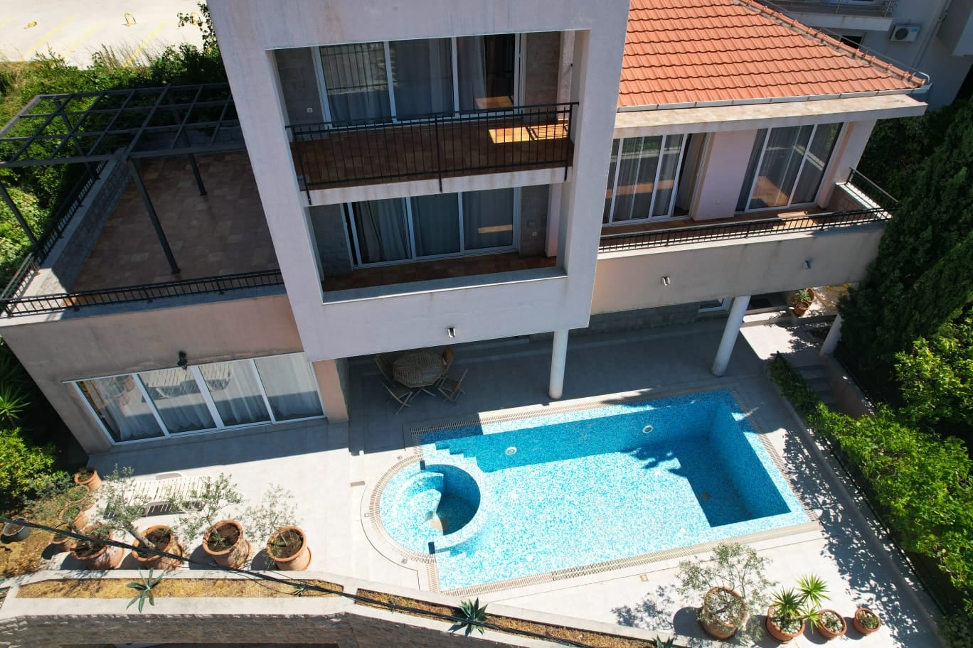 Two-story villa with a pool and terrace in Bečići, Montenegro: aerial view of a modern house with a tiled roof.