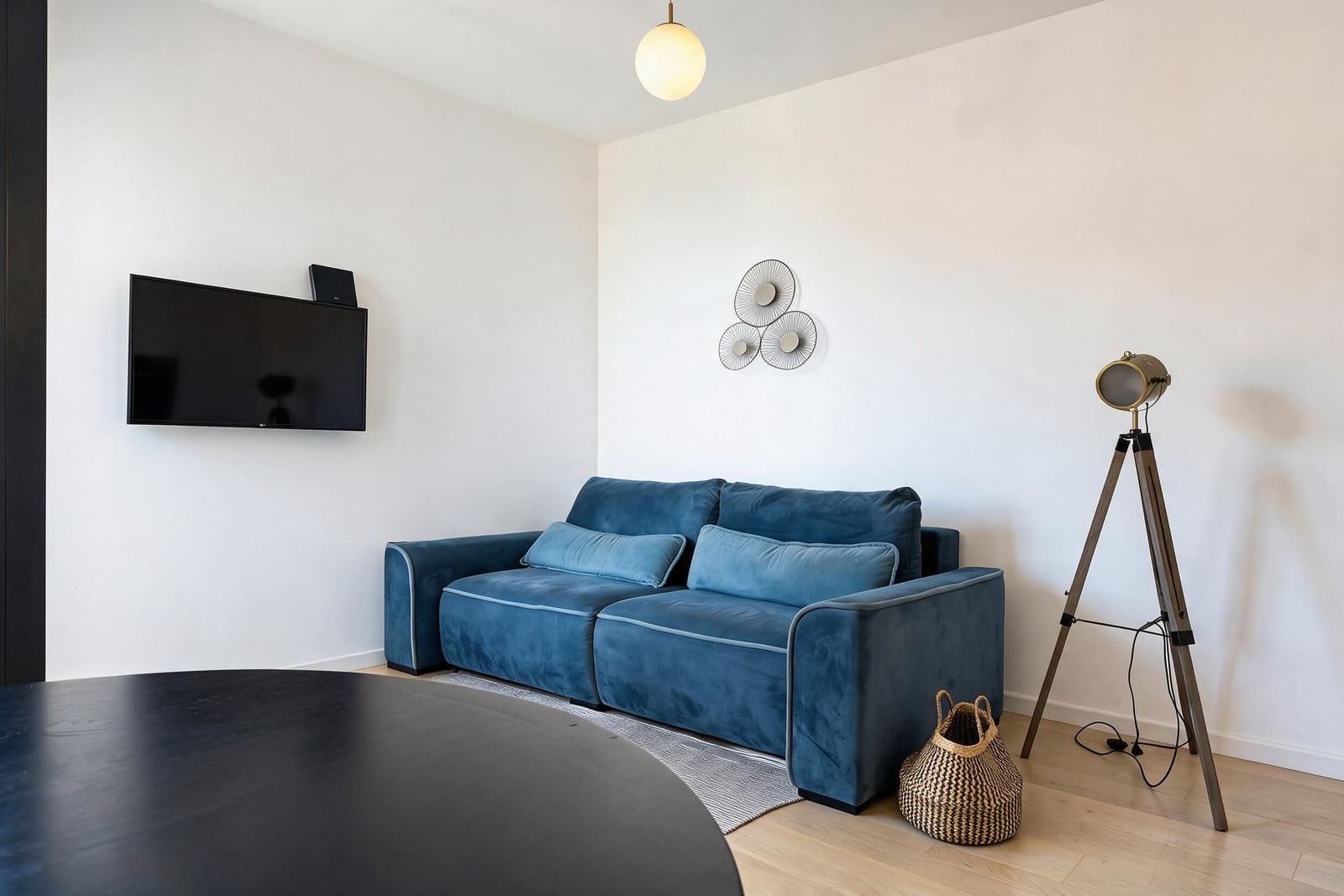 Modern living room with a blue sofa, TV, and floor lamp in an apartment in Tivat, Montenegro