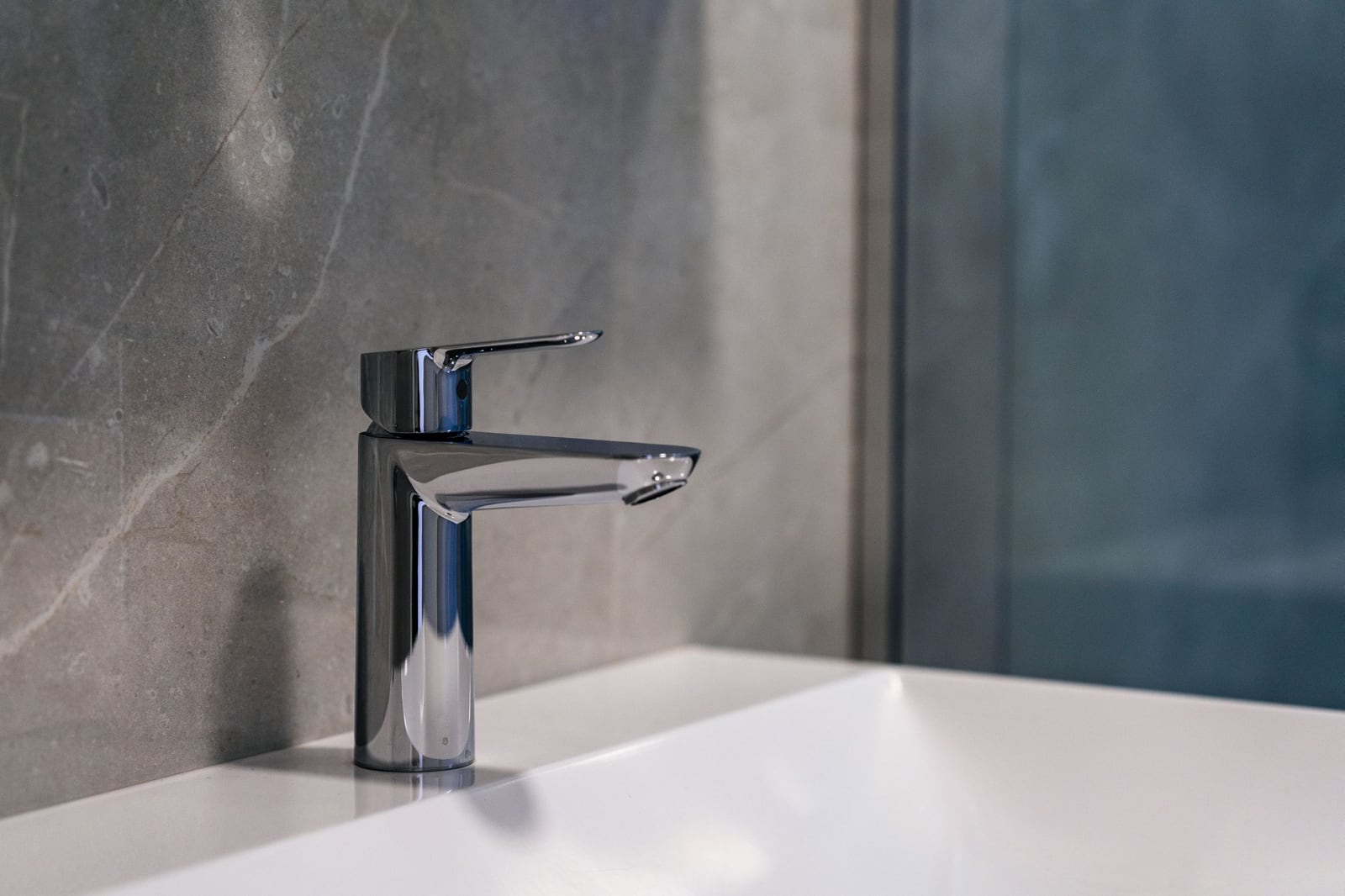Modern chrome faucet and white sink in the bathroom of a residential complex in Budva, Montenegro.