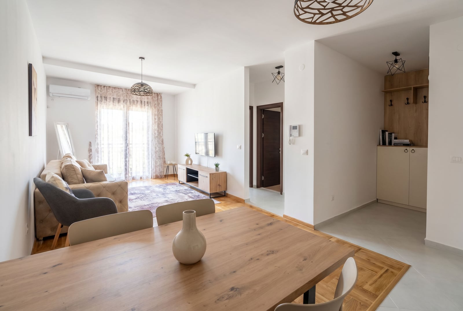 Modern living room with a dining area in an apartment, Rafailovici, Montenegro: bright interior, wooden furniture.
