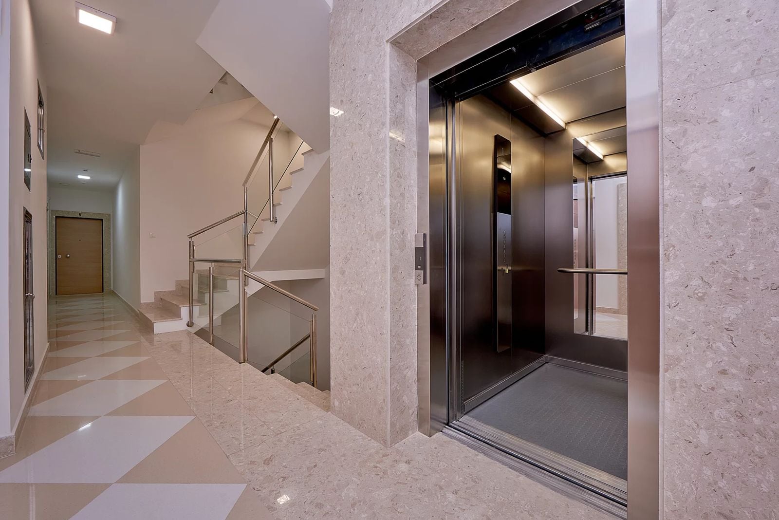 Modern elevator and marble-finished staircase in a residential complex in Dobrota, Montenegro.