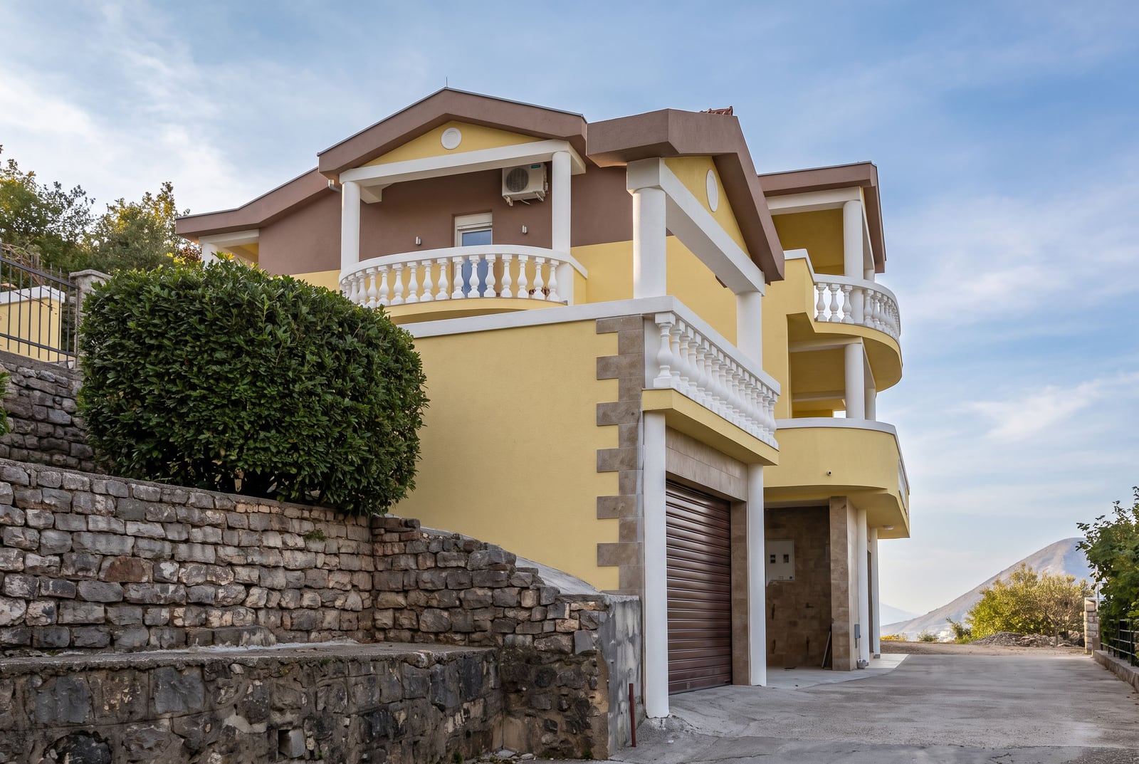 Two-story house in Tivat, Montenegro, with a garage, balconies, and stone finishing