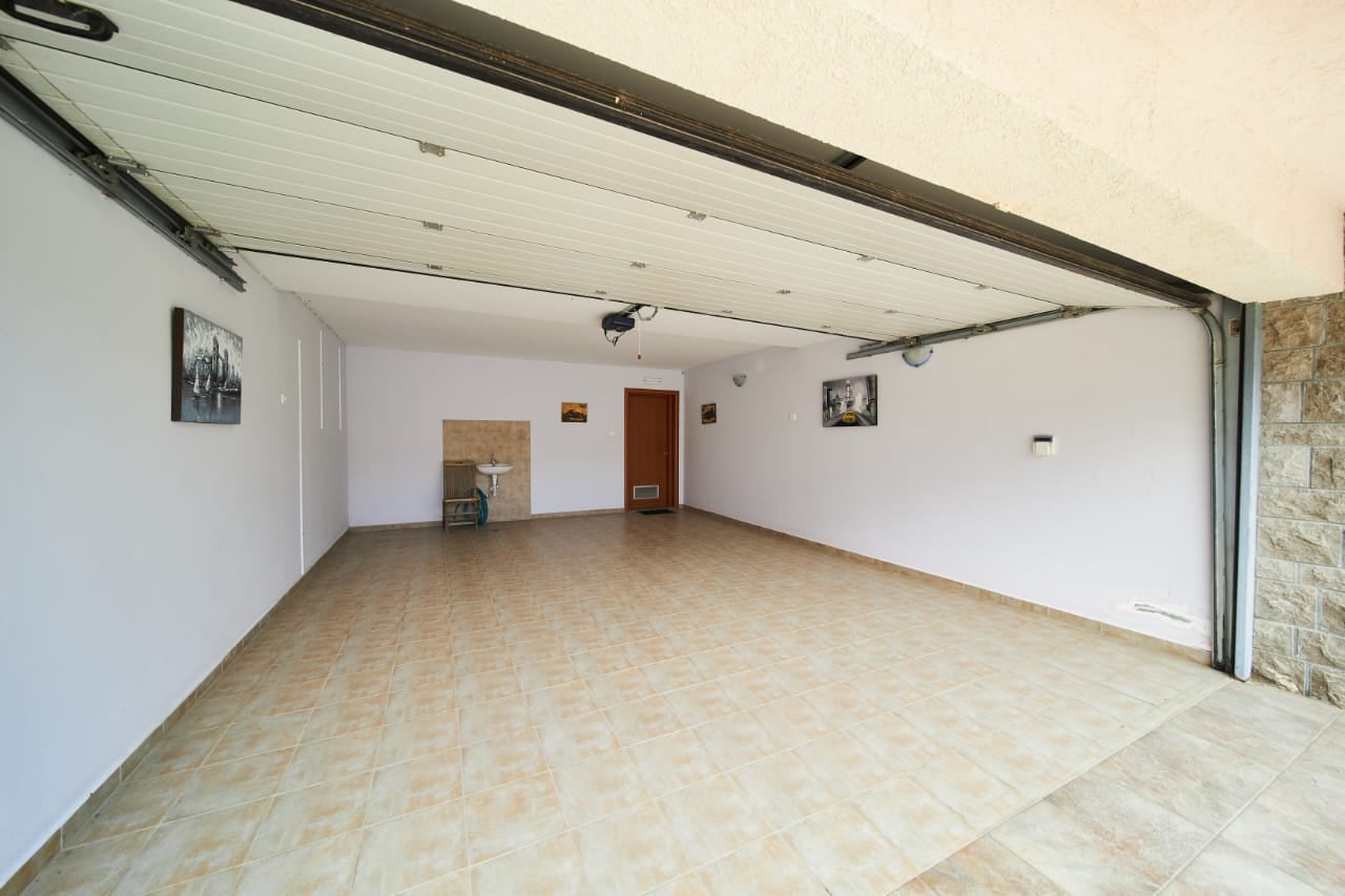 Spacious garage with automatic doors and tiled flooring in a villa in Becici, Montenegro.