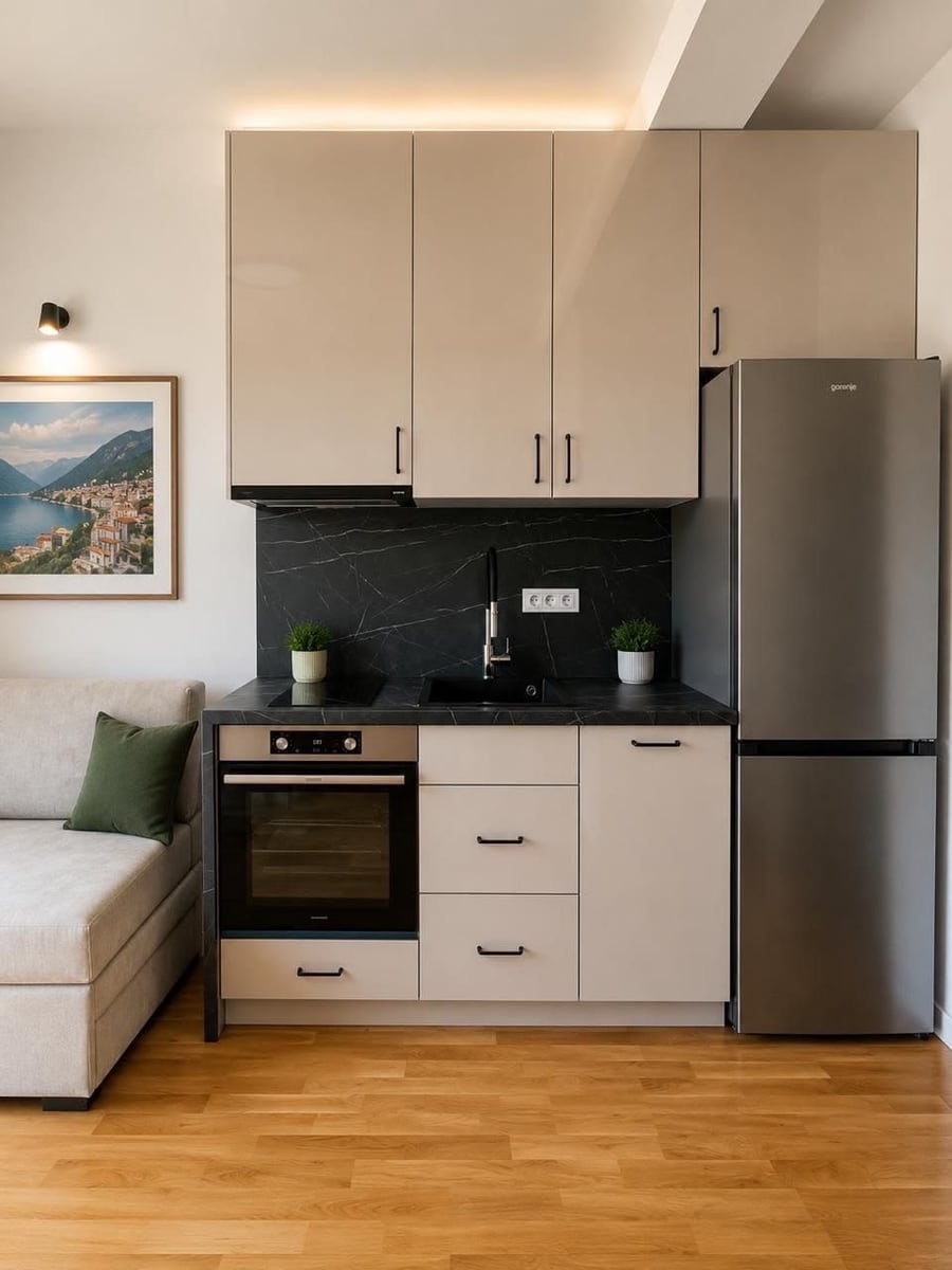 Modern kitchen in a residential complex in Herceg Novi, Montenegro: beige cabinetry, black marble-effect backsplash, and Gorenje appliances.