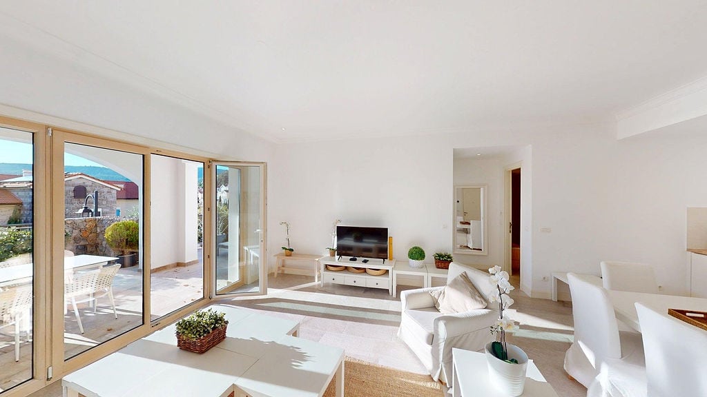 Bright living room with panoramic windows and terrace access in an apartment, Luštica, Montenegro. Modern interior.
