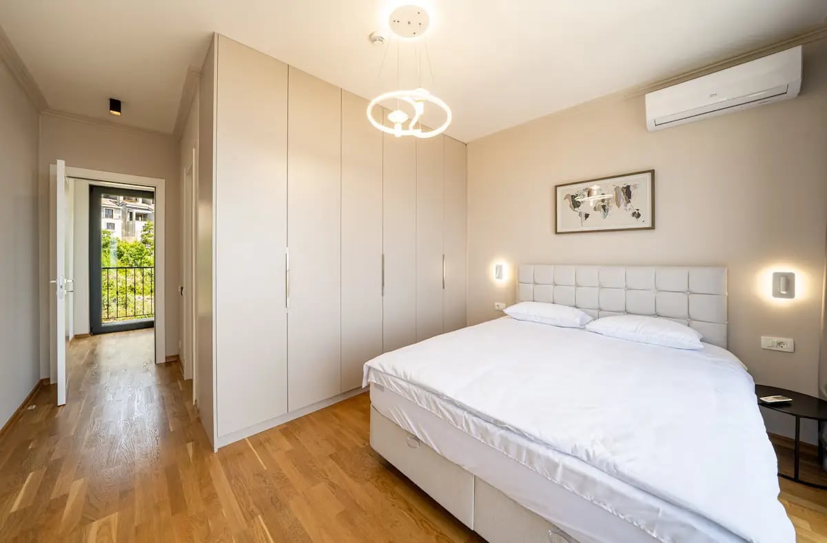 Modern bedroom with a double bed and built-in wardrobe in a villa in Rezevici, Montenegro.