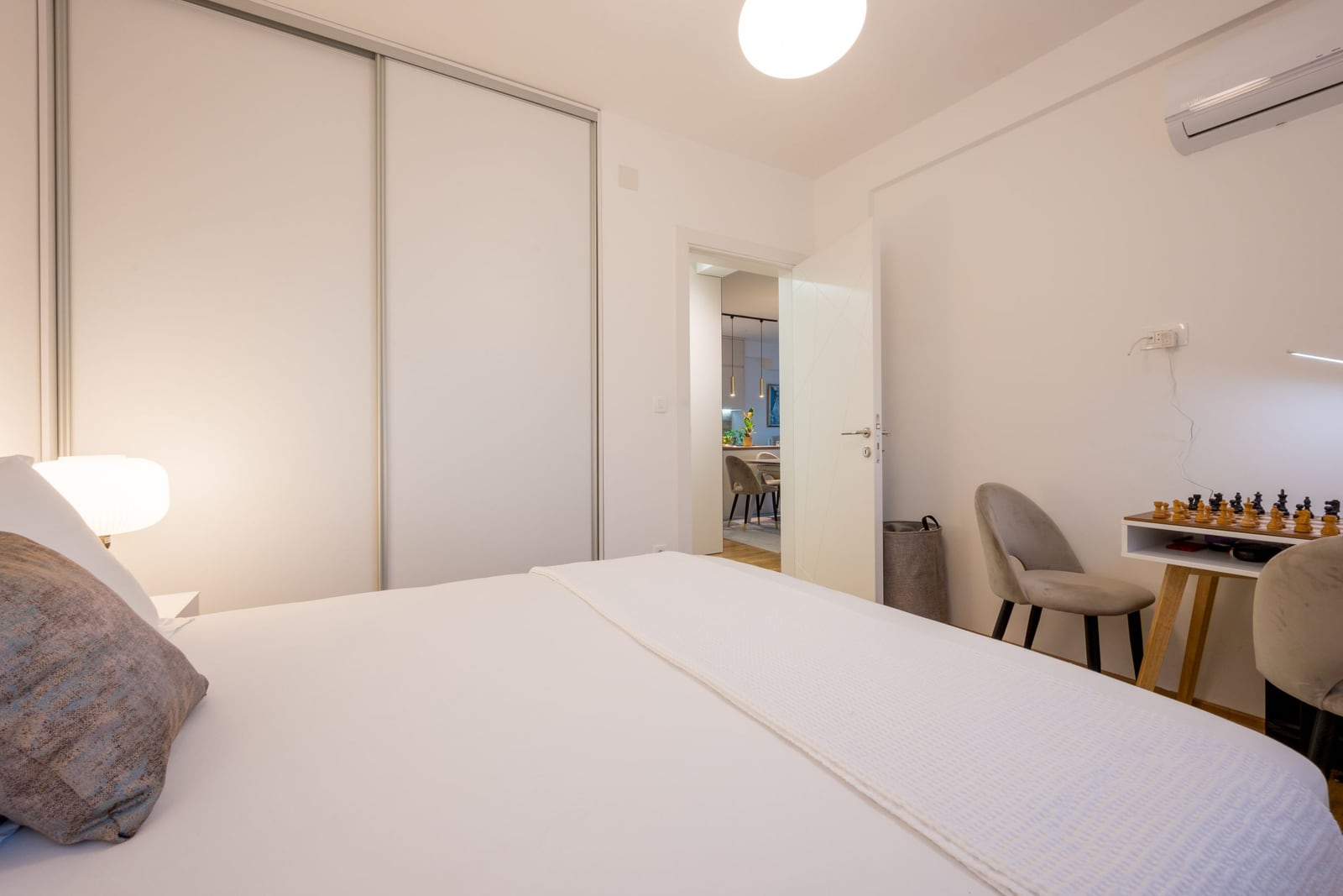 Bright bedroom in a Tivat apartment, Montenegro: double bed, built-in wardrobe, desk, and air conditioning.