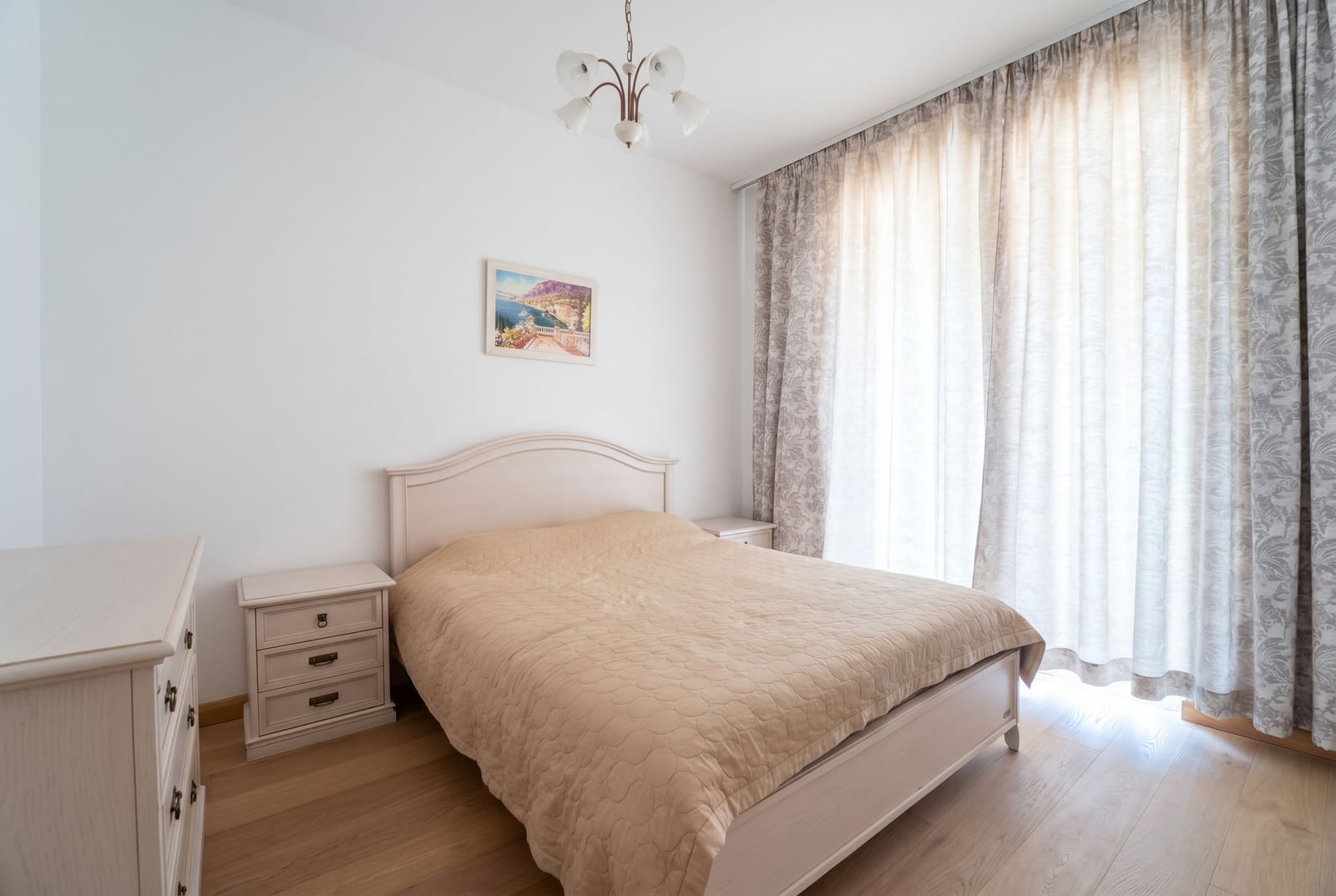 Bright bedroom with a double bed and classic-style furniture in an apartment in Budva, Montenegro.