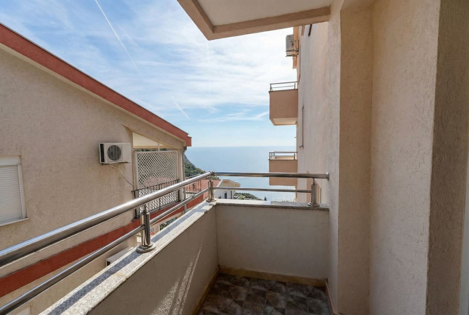 Studio balcony in Budva, Montenegro, with a metal railing and panoramic view of the Adriatic Sea.