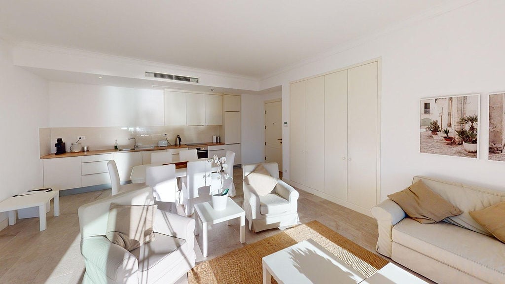 Bright living room with a modern-style kitchen, apartment in Luštica, Montenegro: white furniture and cozy interior.