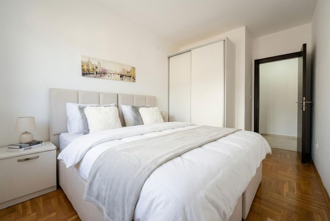 Bright bedroom with a double bed and a built-in wardrobe in an apartment in Budva, Montenegro. Modern interior.
