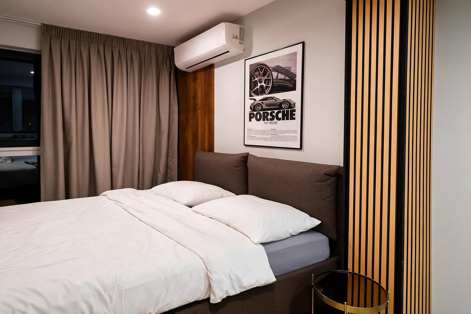 Modern bedroom featuring a double bed with white linens, brown headboard, and a Porsche poster on the wall.