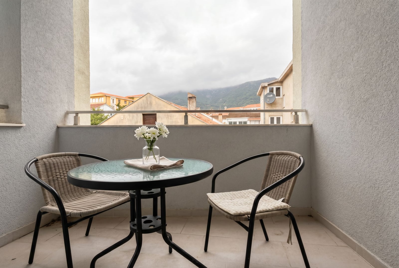 Cozy balcony with wicker chairs and mountain views in an apartment, Budva, Montenegro.